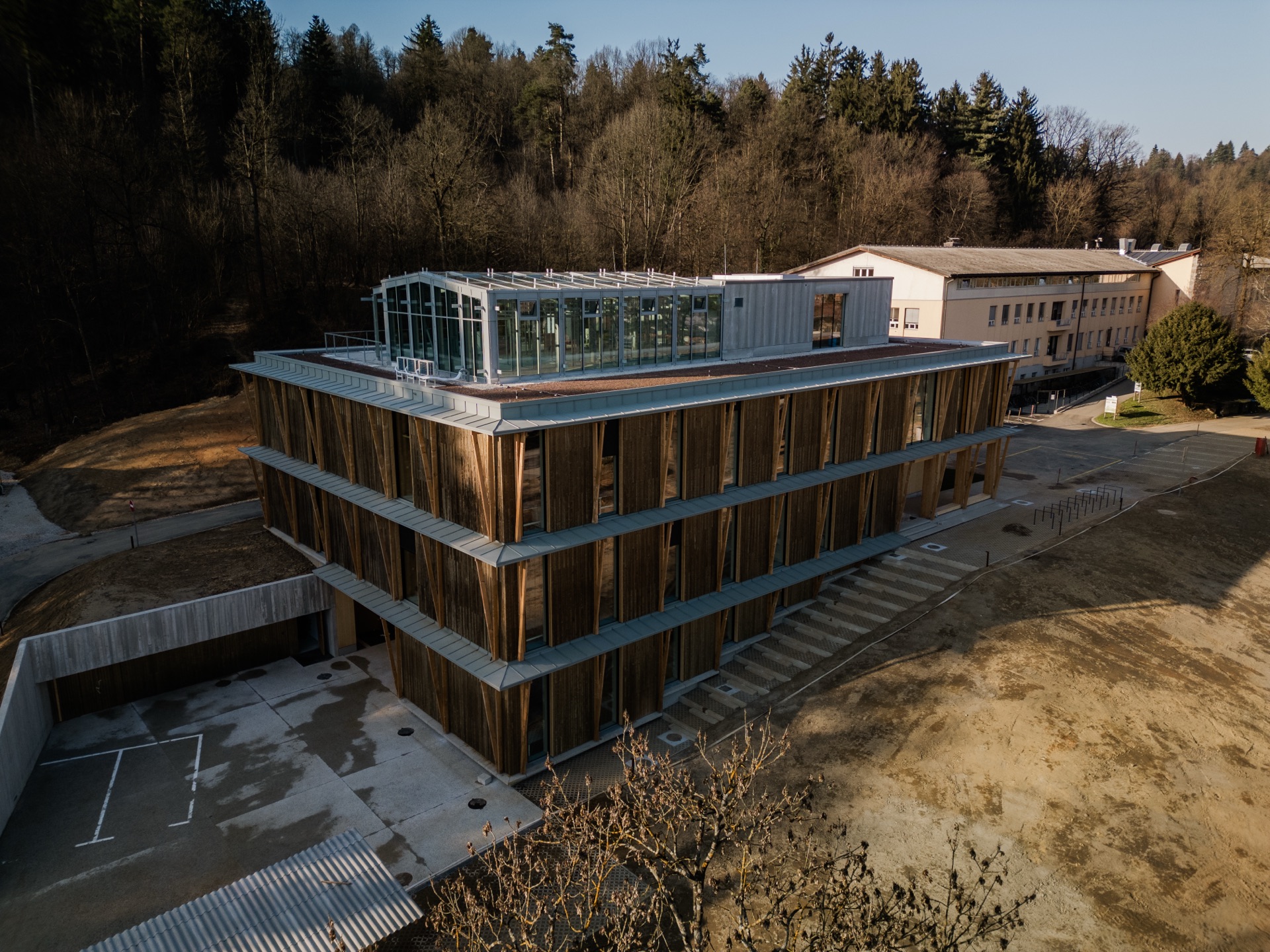 Aerial view of a timber-clad building set in forest