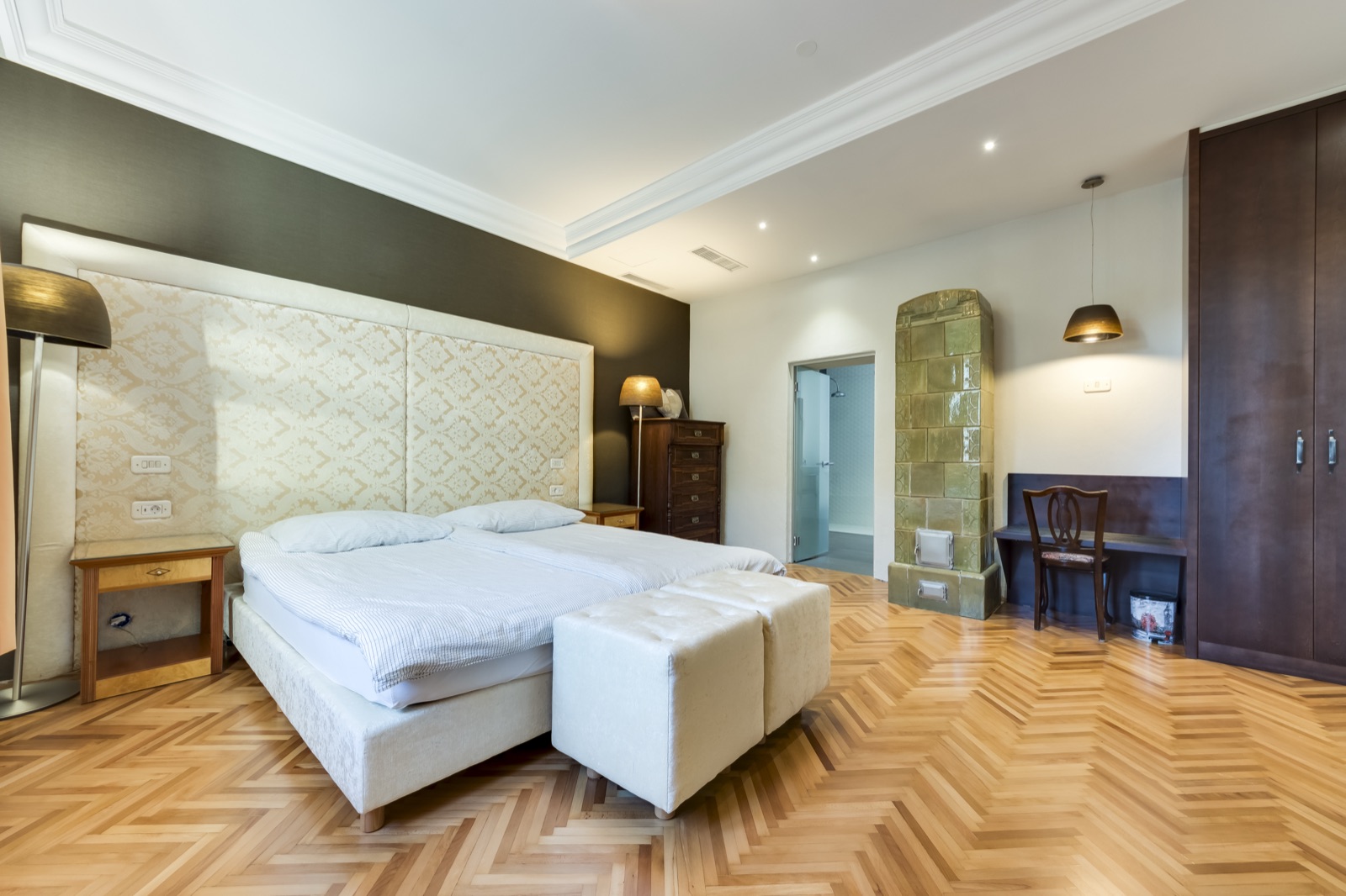 Spacious bedroom with tiled stove and workspace